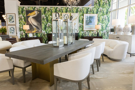 Restoration Hardware, or RH, dining set at Consign & Design consignment furniture showroom in Palm Beach Gardens. The table features a wood top and a metallic base and is paired with white upholstered chairs.  
