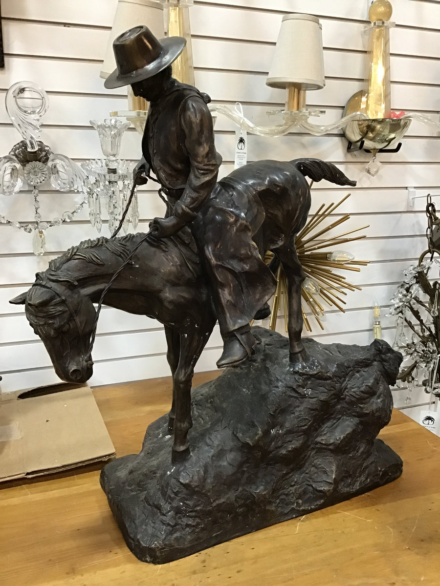 BRONZE COWBOY ON A HORSE COMING DOWN THE HILL