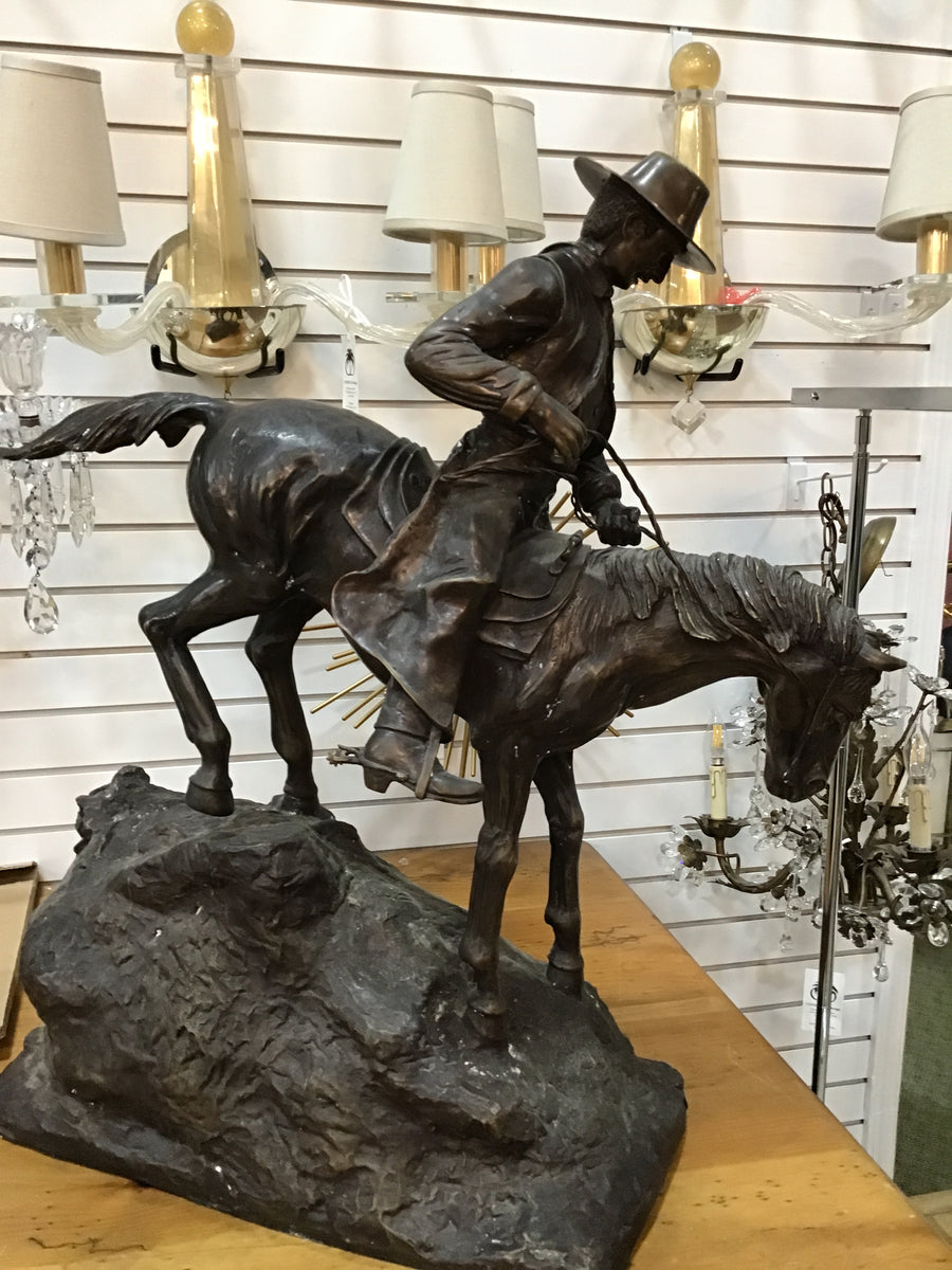 BRONZE COWBOY ON A HORSE COMING DOWN THE HILL